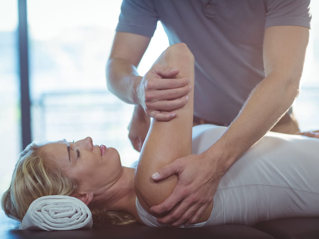a physiotherapist is fixing a frozen shoulder